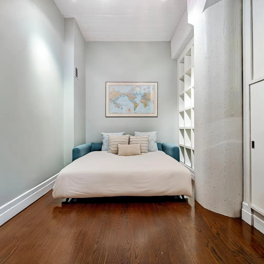 a bedroom with a bed and wooden floor