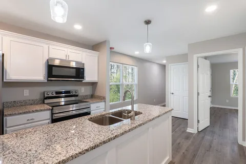 a kitchen with stainless steel appliances granite countertop a sink and a stove