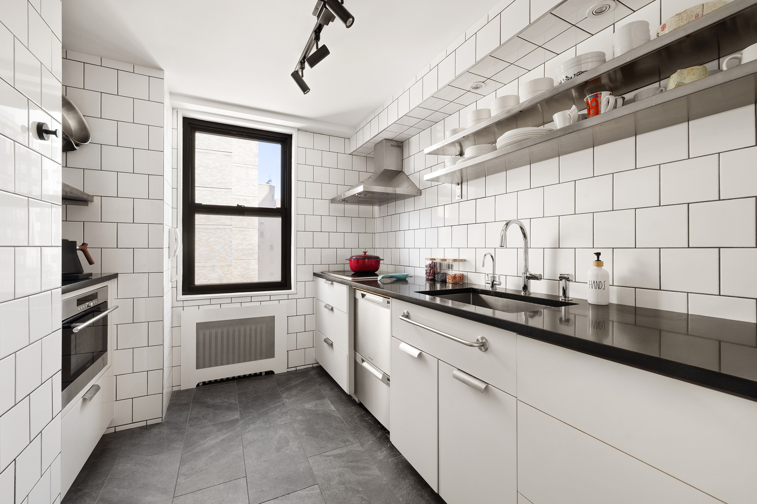 1065 Park Avenue, Unit 10CD Manhattan, NY 10128 - Photo 3 of 10 a kitchen with white cabinets and appliances