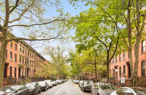 a row of cars parked in front of brick building