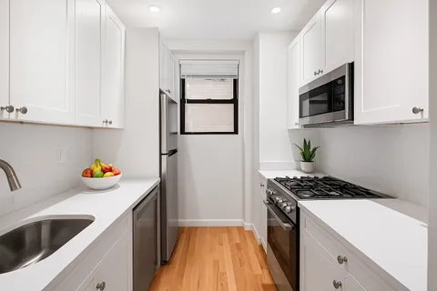 a kitchen with stainless steel appliances a stove a sink and a refrigerator