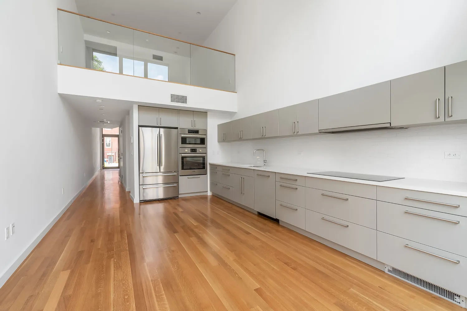 a kitchen with cabinets and wooden floor