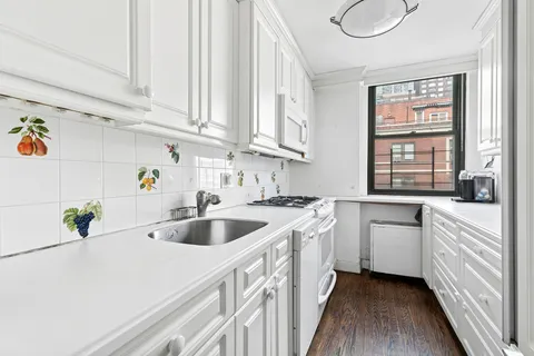 a kitchen with white cabinets and white appliances