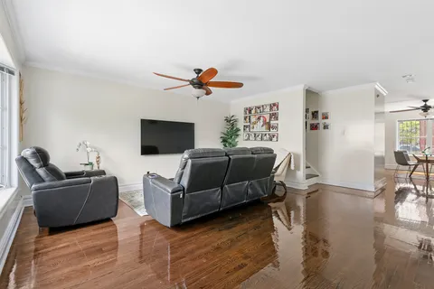 a living room with furniture flat screen tv and wooden floor