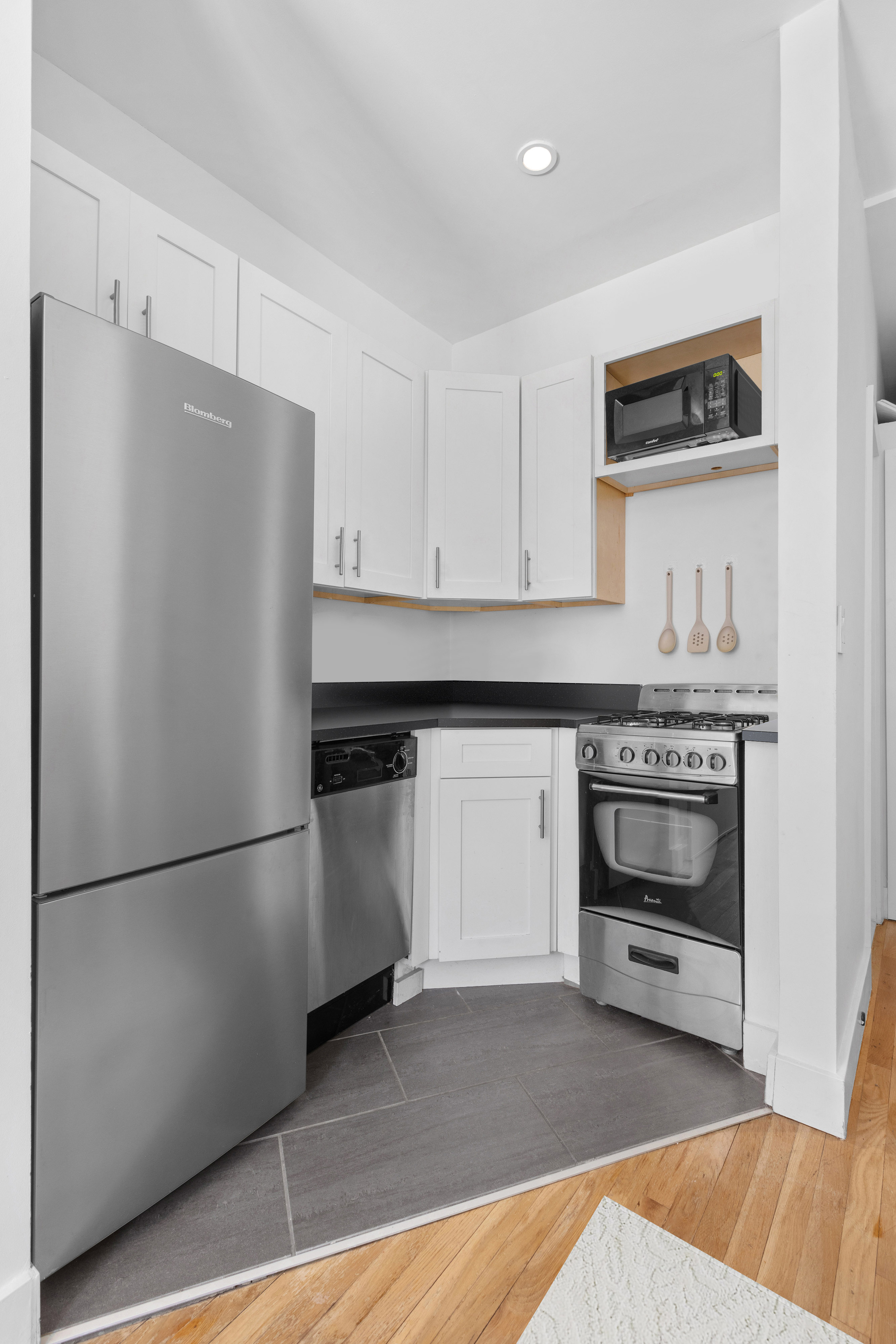 1582 York Avenue, Unit 2A Manhattan, NY 10028 - Photo 3 of 5 a kitchen with a refrigerator and a stove