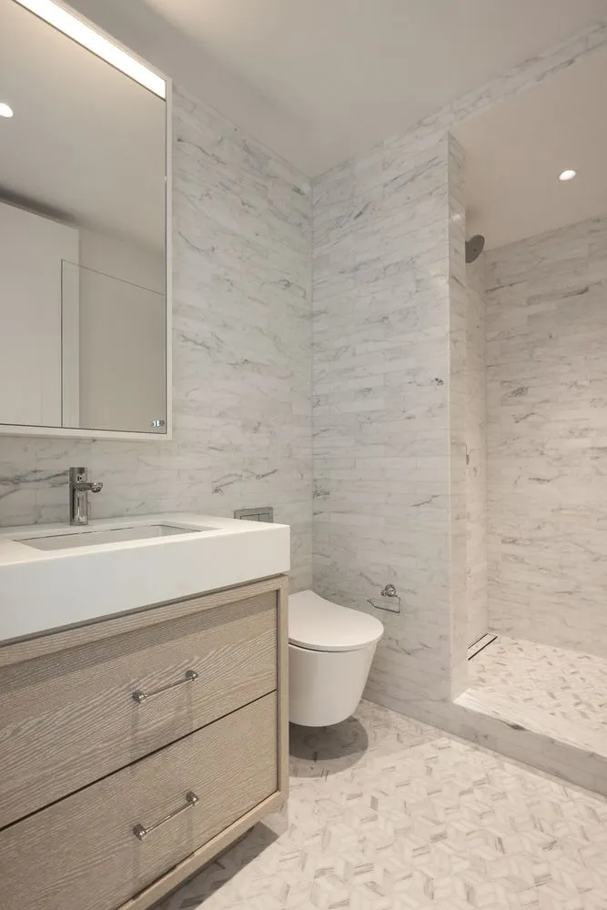 a bathroom with a granite countertop toilet a sink and a mirror