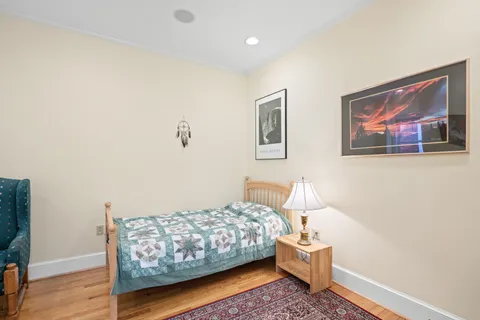 a bedroom with a bed and wooden floor
