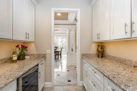 a kitchen with granite countertop a sink dishwasher stove and cabinets