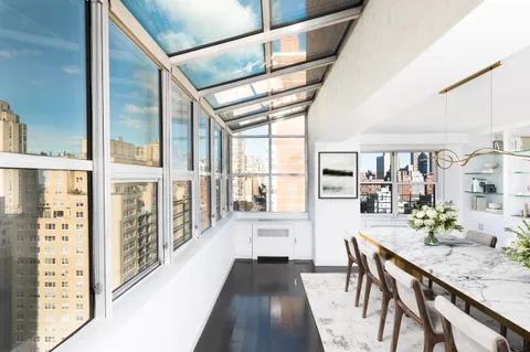 a view of a hallway with furniture and wooden floor