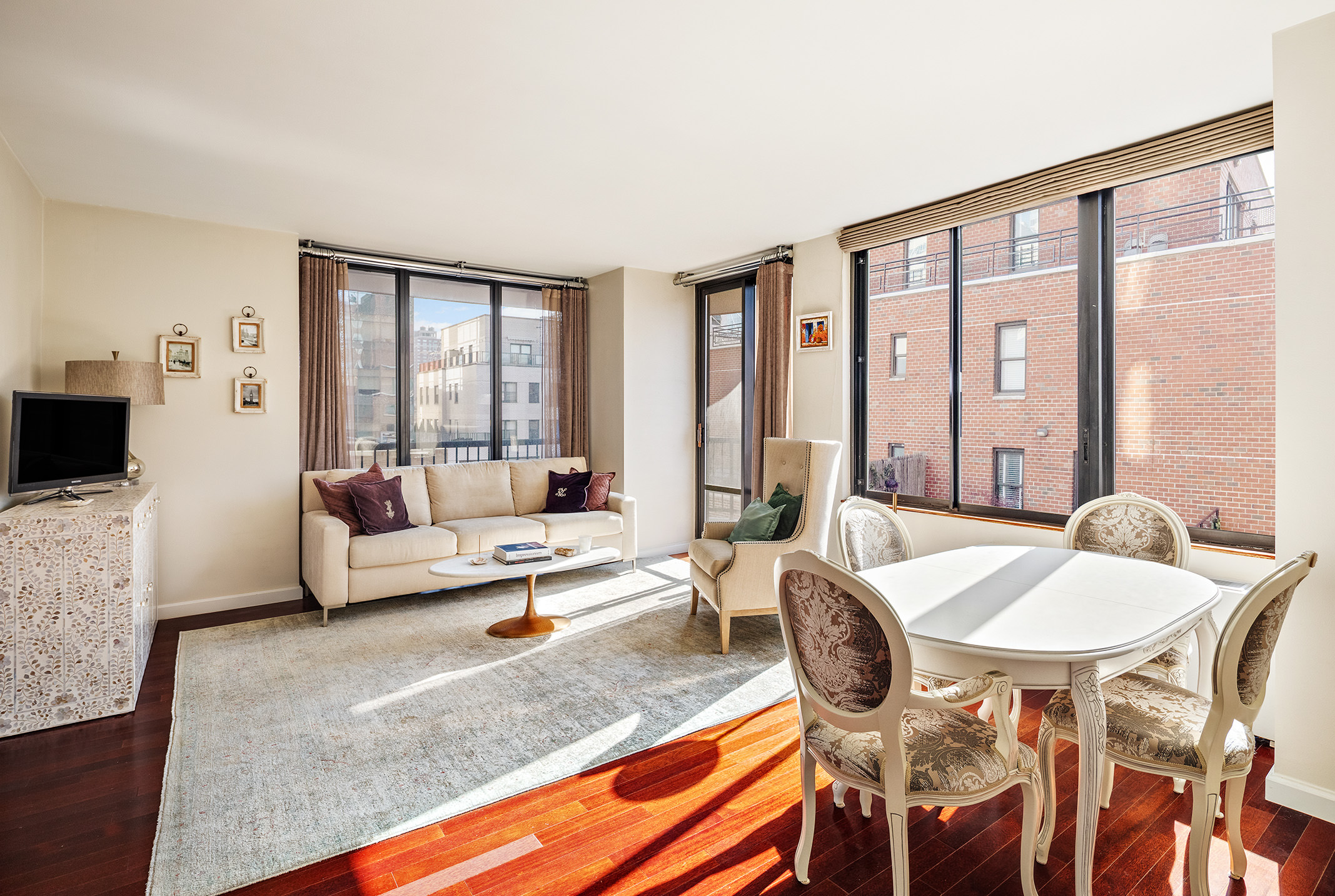 304 East 65th Street, Unit 10D Manhattan, NY 10065 - Photo 2 of 14 a living room with furniture and a flat screen tv
