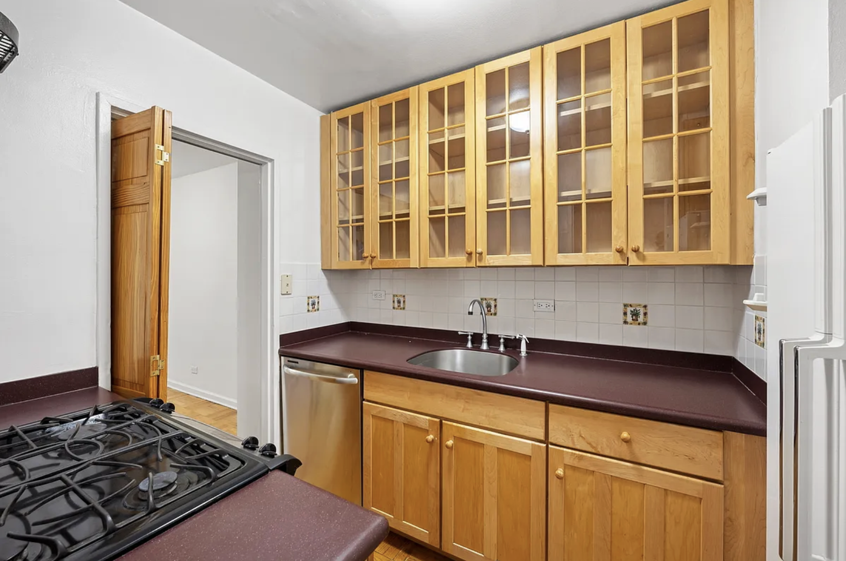 136 East 56th Street, Unit 9J Manhattan, NY 10022 - Photo 12 of 14 a kitchen with stainless steel appliances granite countertop a sink stove and refrigerator