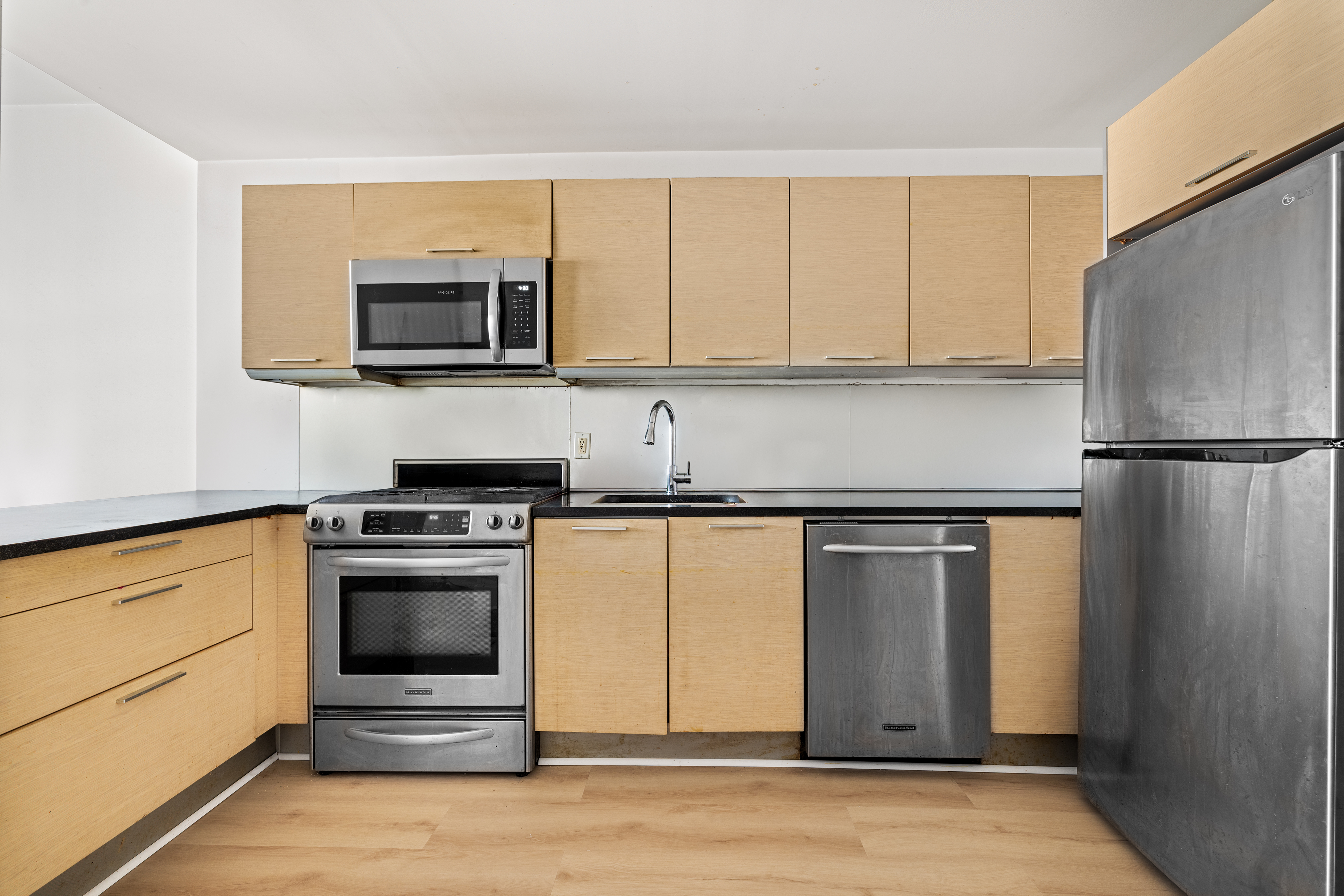 350 West 42nd Street, Unit 5D Manhattan, NY 10036 - Photo 2 of 13 a kitchen with stainless steel appliances granite countertop a refrigerator stove and microwave