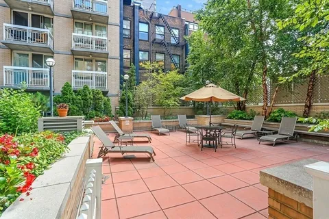 a view of a patio with a table and chairs under an umbrella