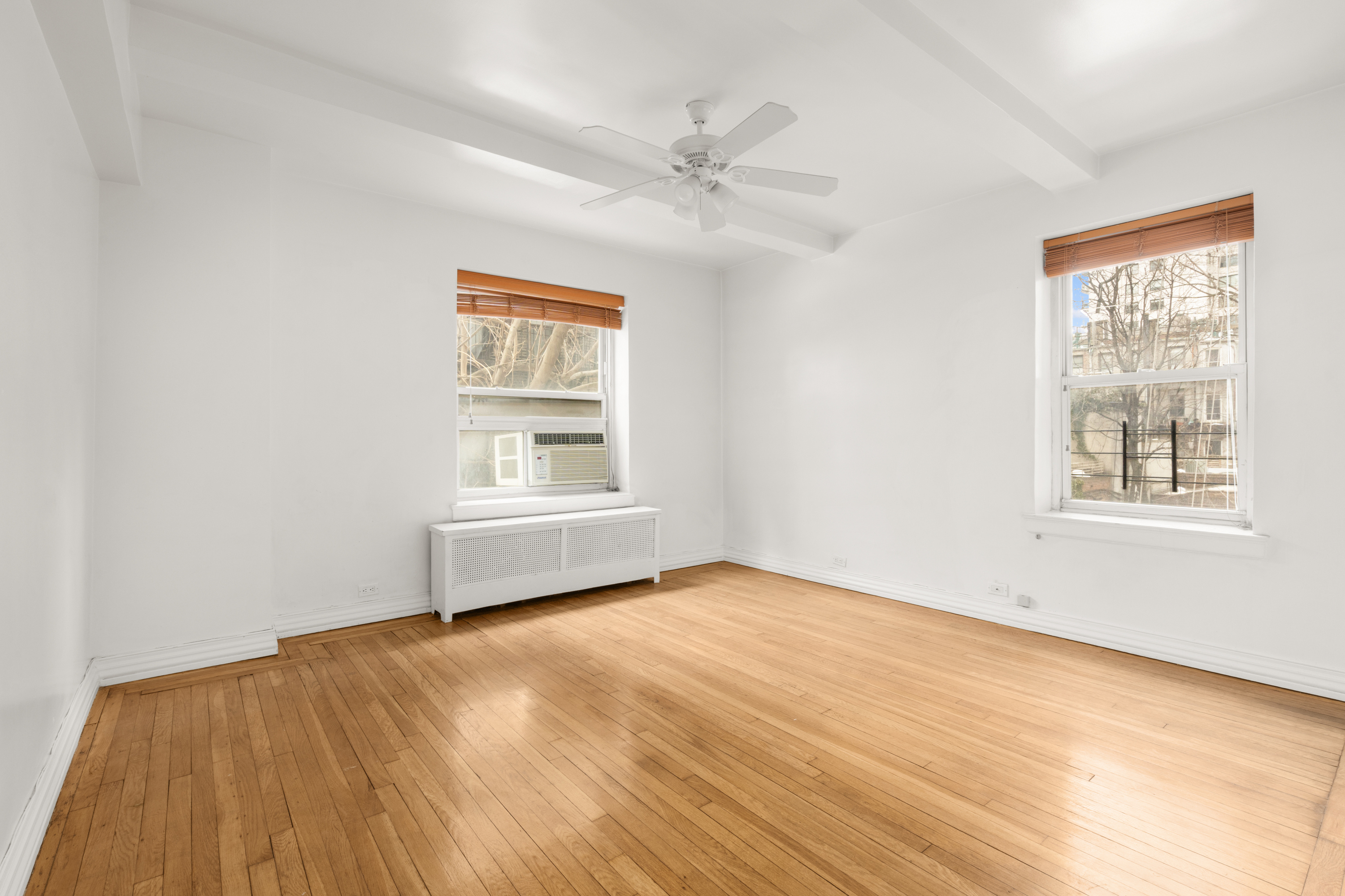 227 East 57th Street, Unit 3DEF Manhattan, NY 10022 - Photo 3 of 13 a view of an empty room with a window and wooden floor