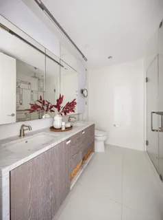 a bathroom with a double vanity sink mirror and toilet