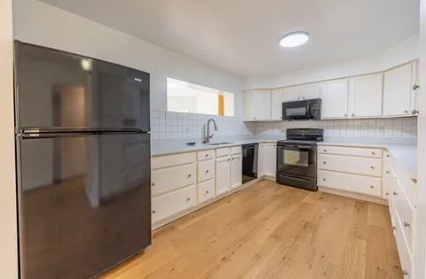 a kitchen with white cabinets and stainless steel appliances