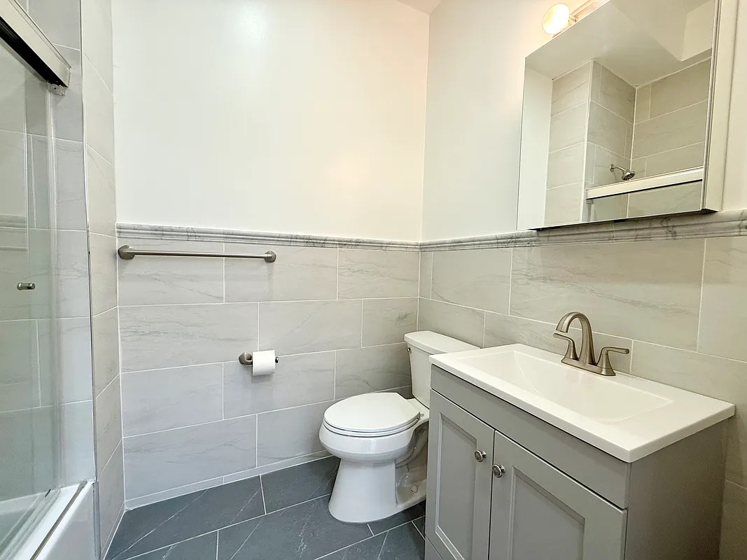 82 74th Street Brooklyn, NY 11209 - Photo 20 of 21 a bathroom with a toilet sink and mirror