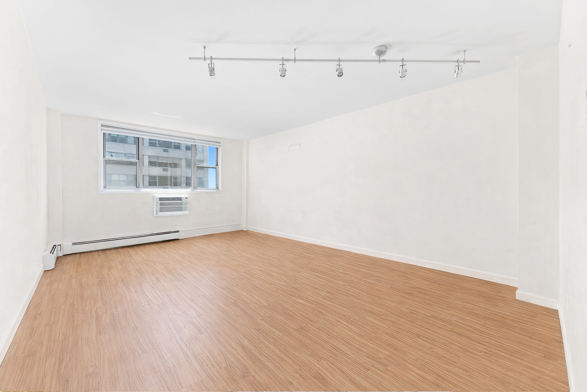 40 Sutton Place, Unit 9J Manhattan, NY 10022 - Photo 9 of 11 a view of a room with wooden floor and cabinet