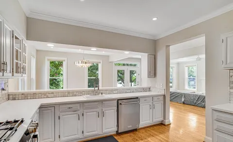 a large white kitchen with a large window