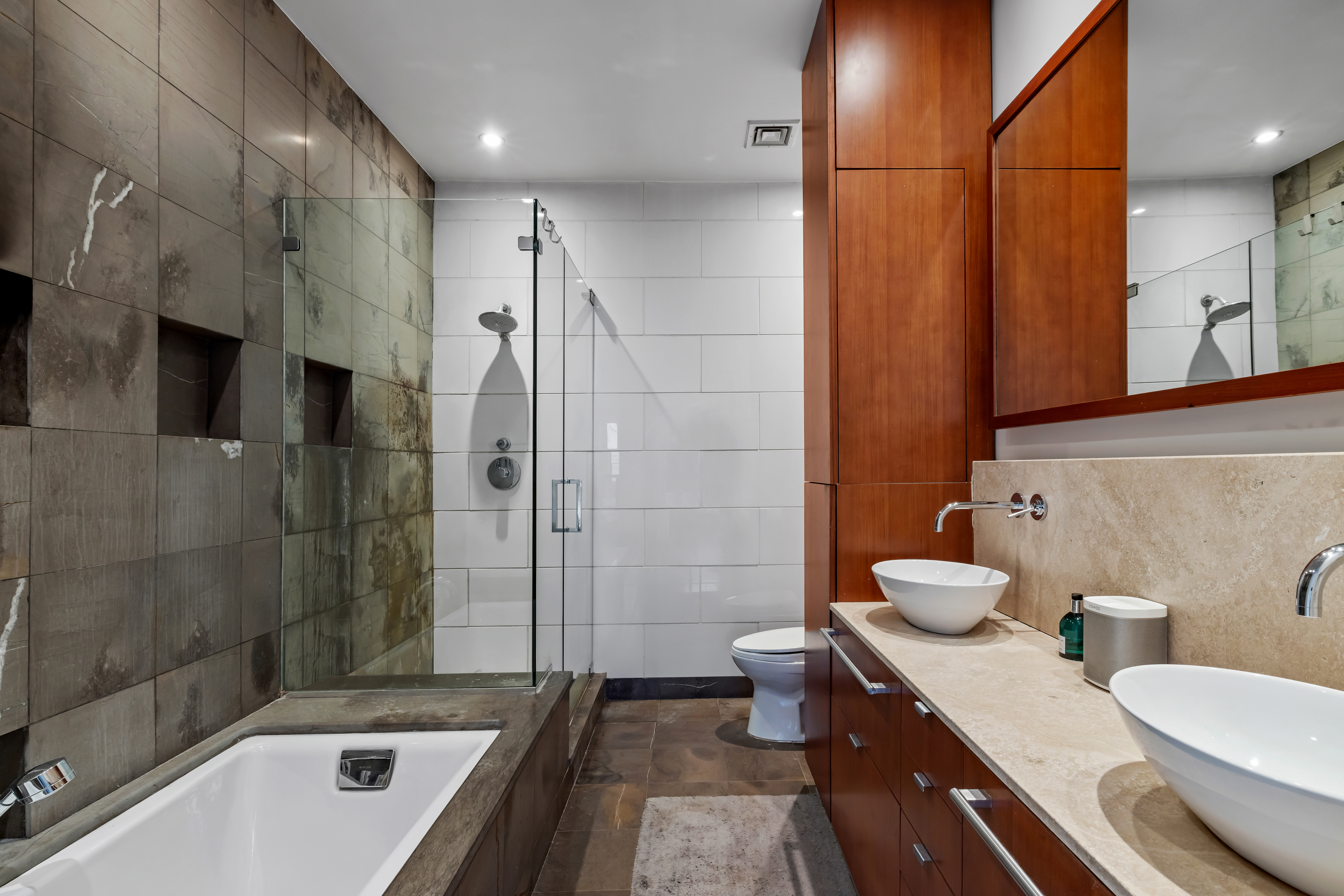 344 Bowery, Unit 3 Manhattan, NY 10012 - Photo 8 of 9 a bathroom with a granite countertop sink a toilet and shower