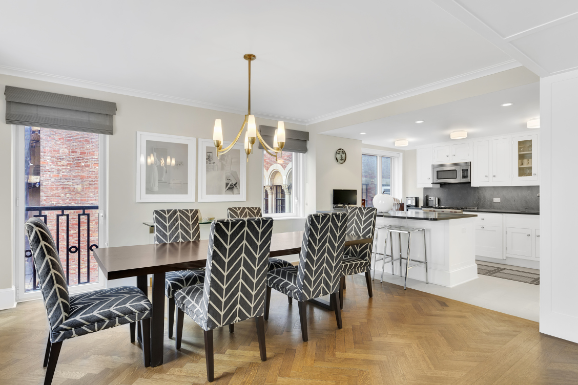 530 Park Avenue, Unit 4A Manhattan, NY 10065 - Photo 4 of 16 a view of a dining room and livingroom with furniture wooden floor a chandelier