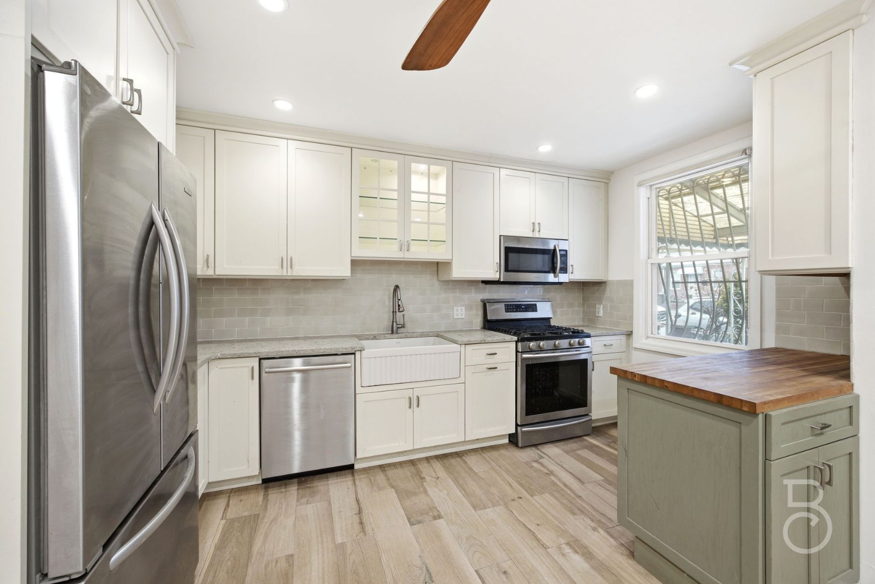 22-61 46th Street Queens, NY 11105 - Photo 4 of 24 a kitchen with stainless steel appliances granite countertop a refrigerator a sink dishwasher a stove and white countertops with wooden floor