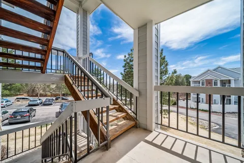 a view of staircase with railing and white walls