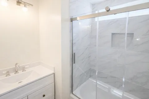 a bathroom with a shower and a sink
