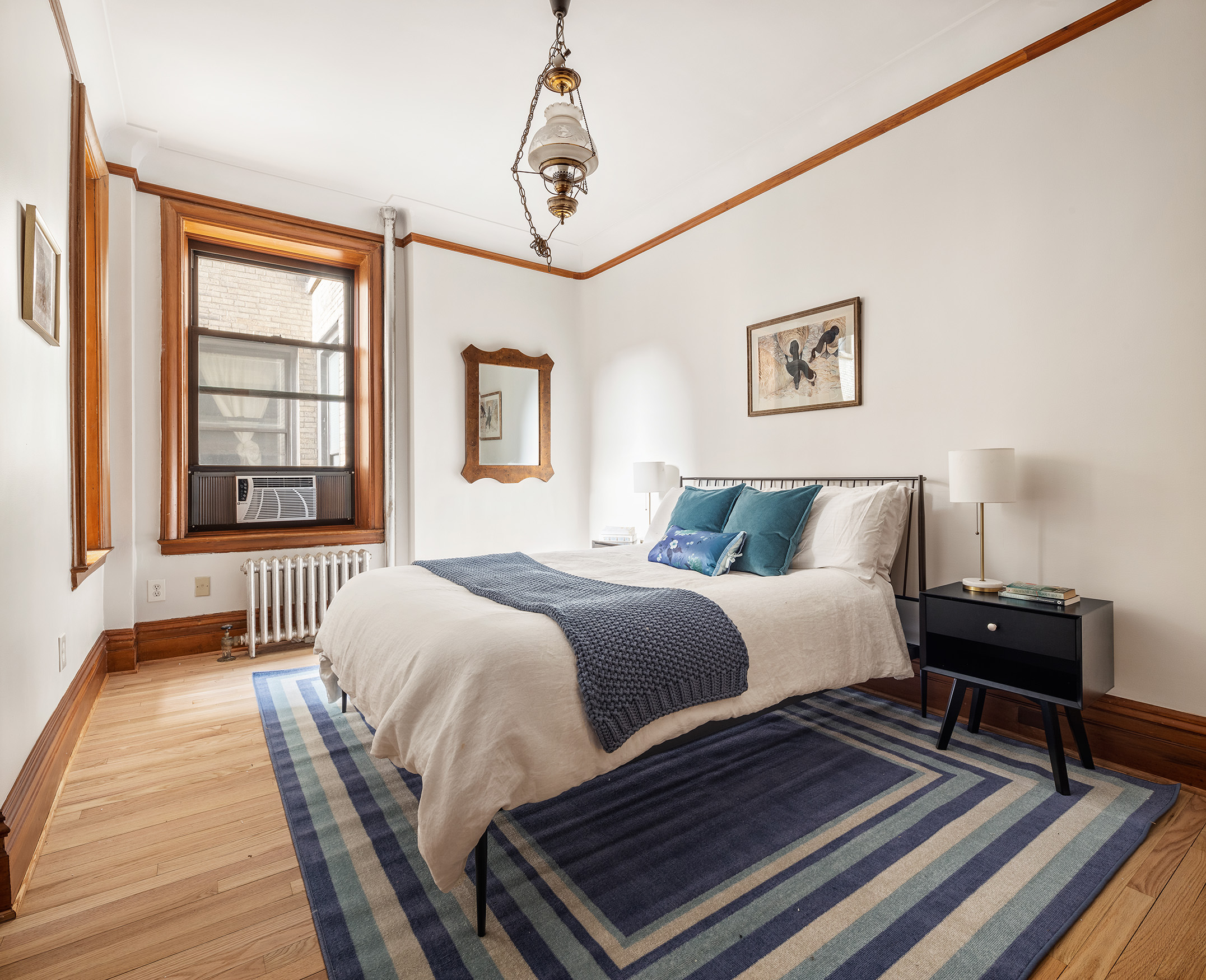 790 Riverside Drive, Unit 4C Manhattan, NY 10032 - Photo 5 of 11 a bedroom with a bed two lamps and a rug