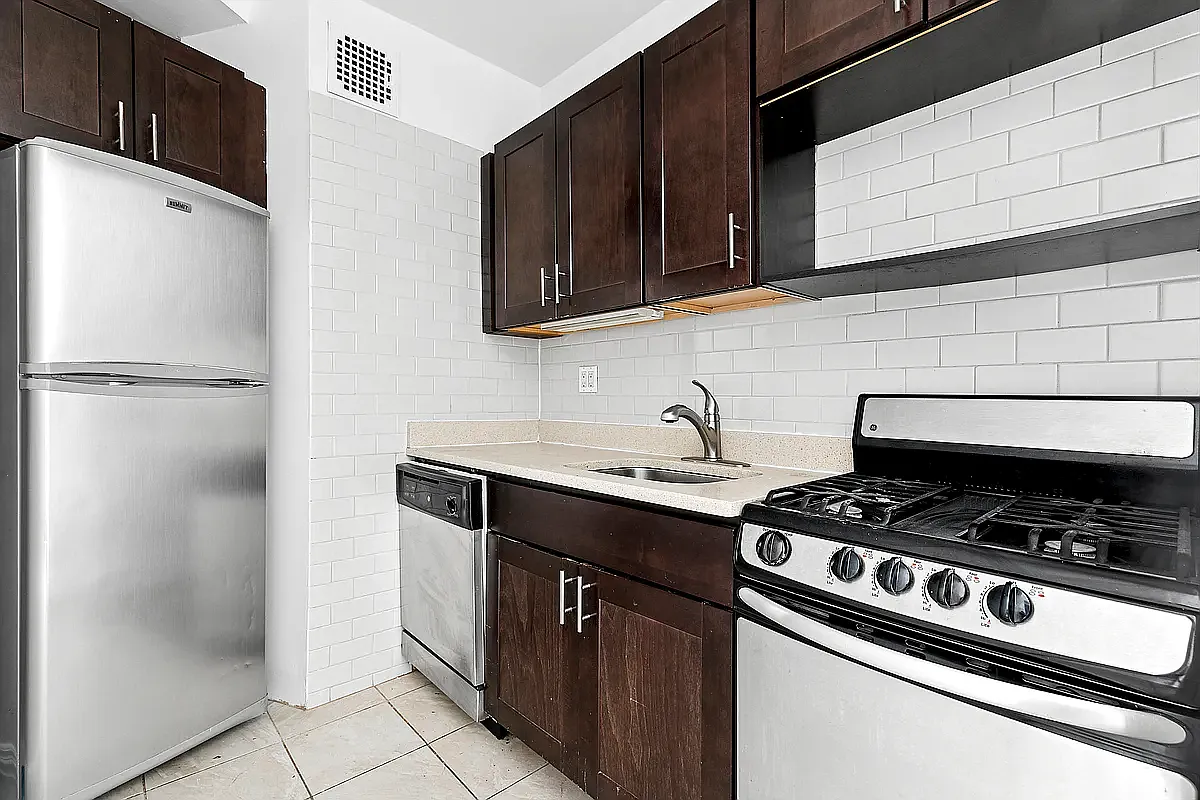 643 9th Avenue, Unit 5A Manhattan, NY 10036 - Photo 2 of 6 a kitchen with stainless steel appliances granite countertop a sink stove and refrigerator