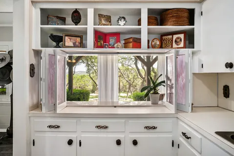 a kitchen with a lots of white cabinets and a wooden floor