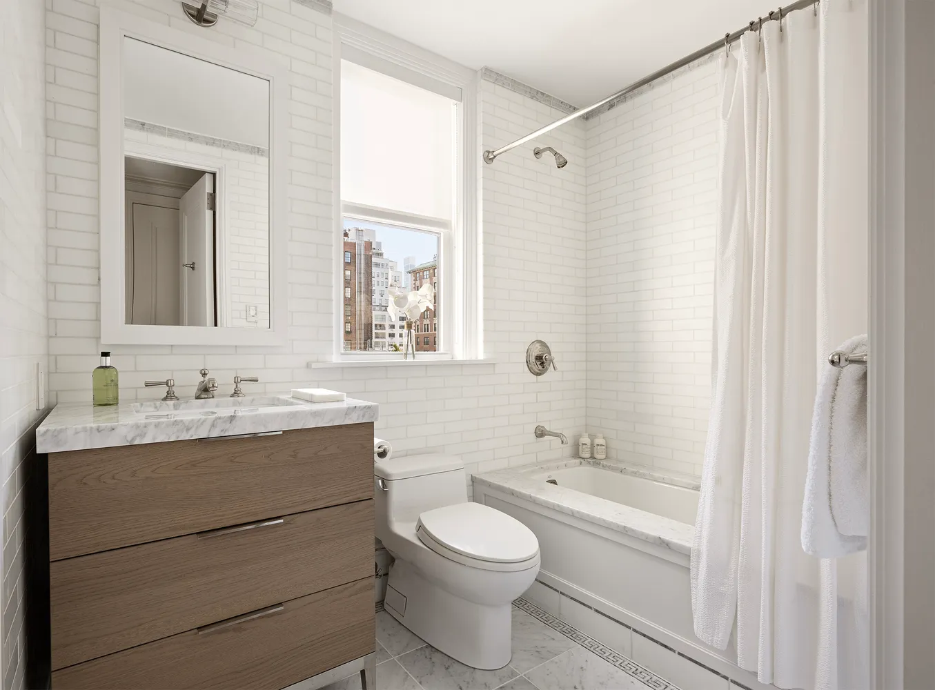 a bathroom with a toilet a sink a mirror a bathtub and vanity