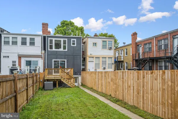 a view of a house with wooden deck and furniture