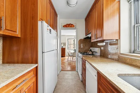 a kitchen with a refrigerator a stove and a sink with wooden floor
