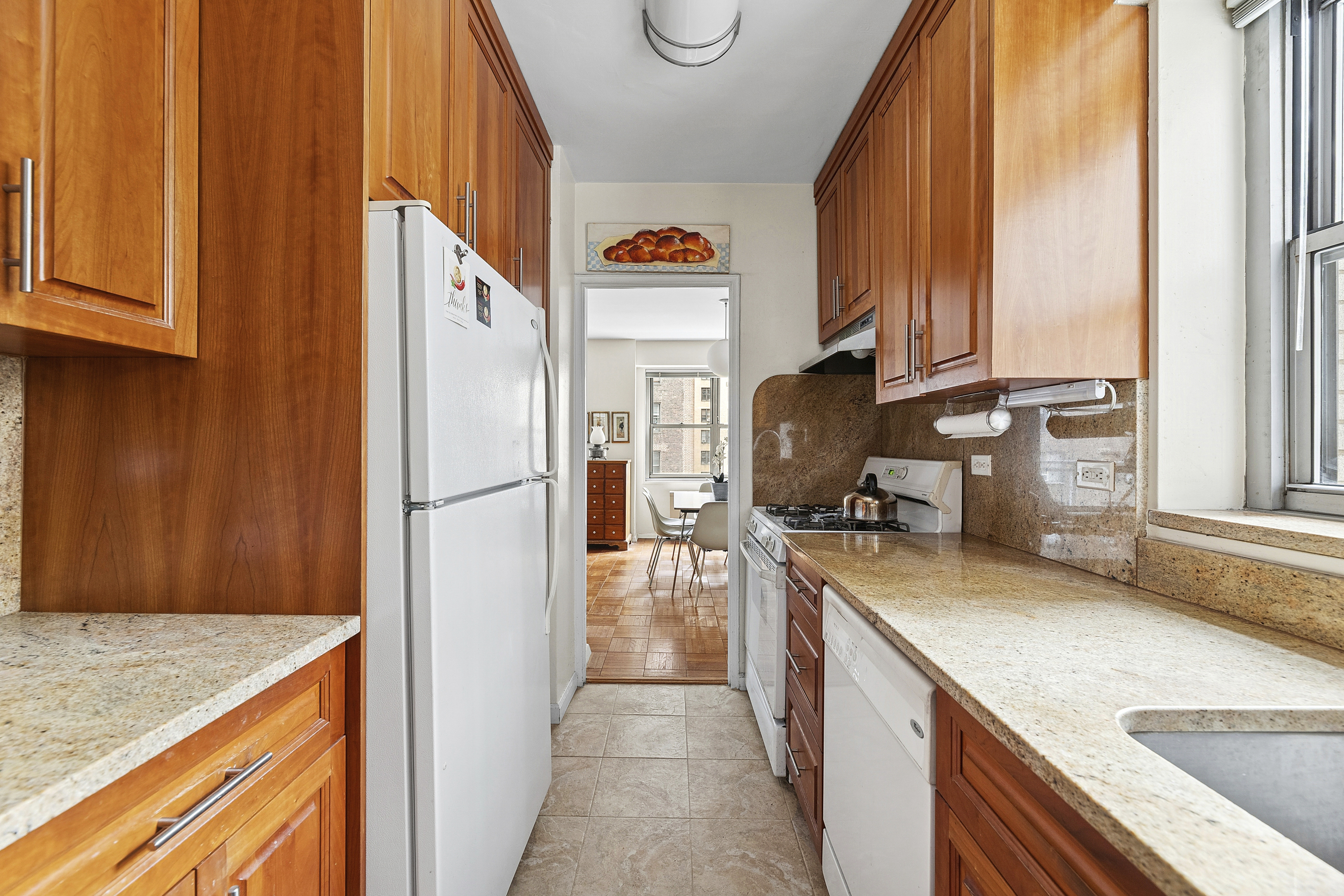 400 East 56th Street, Unit 4R Manhattan, NY 10022 - Photo 2 of 9 a kitchen with a refrigerator a stove and a sink with wooden floor