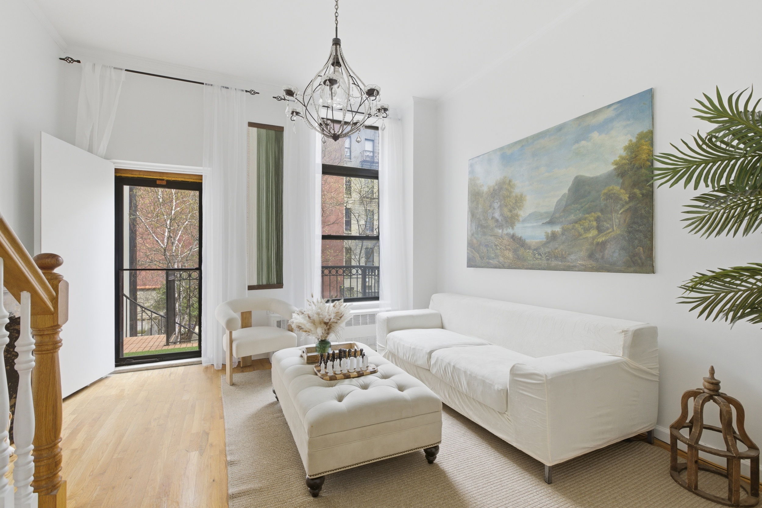 a living room with furniture a chandelier and a flat screen tv