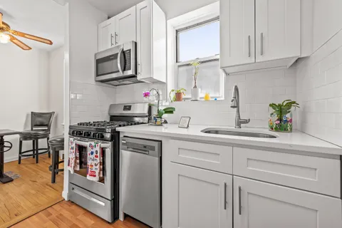 a kitchen with stainless steel appliances granite countertop a sink a stove and a refrigerator