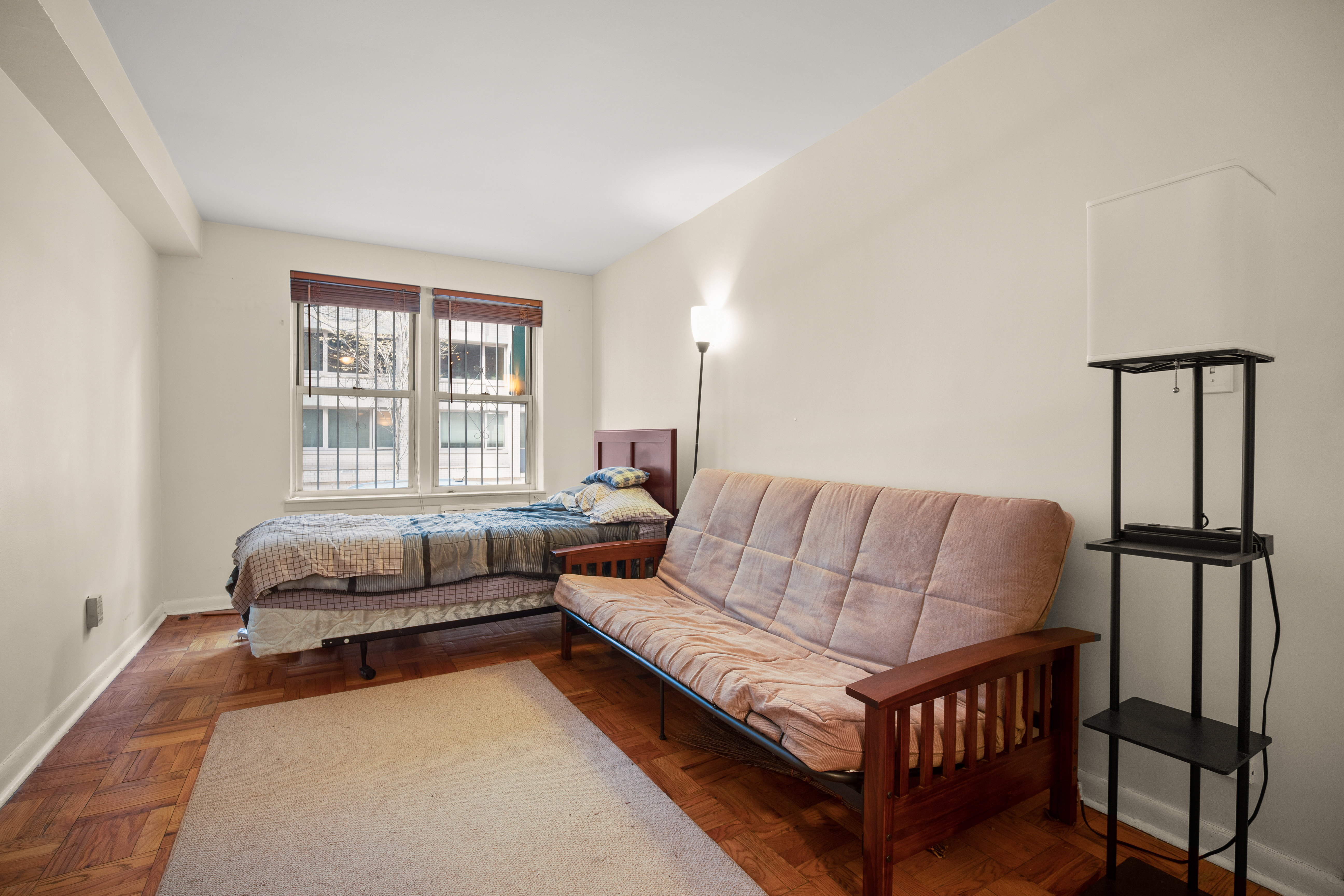 431 East 82nd Street, Unit 1A Manhattan, NY 10028 - Photo 3 of 9 a bedroom with a bed window and couch