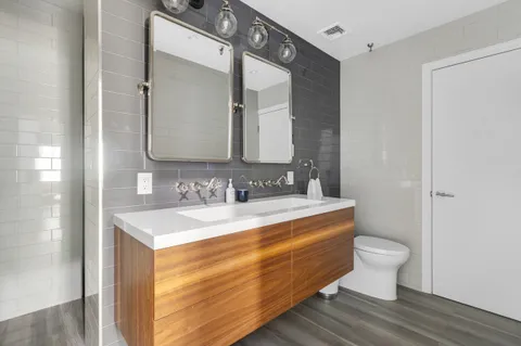 a bathroom with a granite countertop toilet sink and mirror