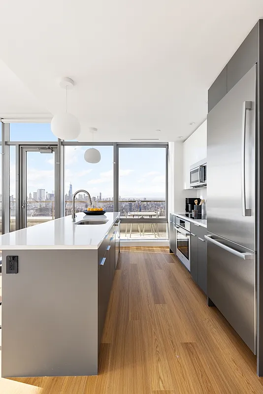 5 South 5th Street, Unit PH2B Brooklyn, NY 11249 - Photo 5 of 27 a large kitchen with a large window a sink and stainless steel appliances