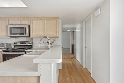 a kitchen with sink a microwave and cabinets