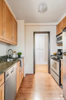 a kitchen with stainless steel appliances granite countertop a sink and a stove top oven