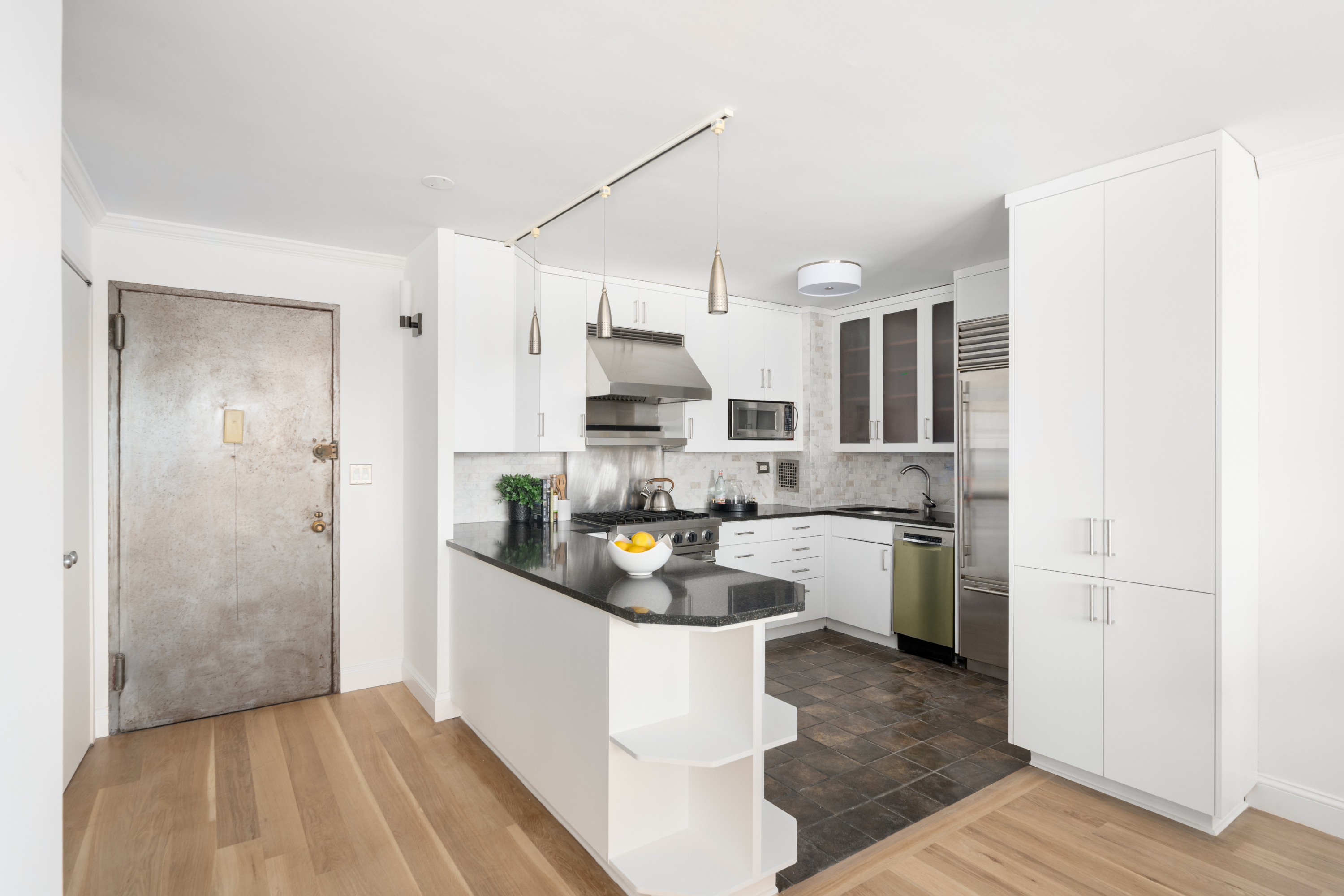 360 West 22nd Street, Unit 15C-14C Manhattan, NY 10011 - Photo 7 of 16 a kitchen with stainless steel appliances granite countertop a refrigerator a sink dishwasher a stove and white cabinets with wooden floor