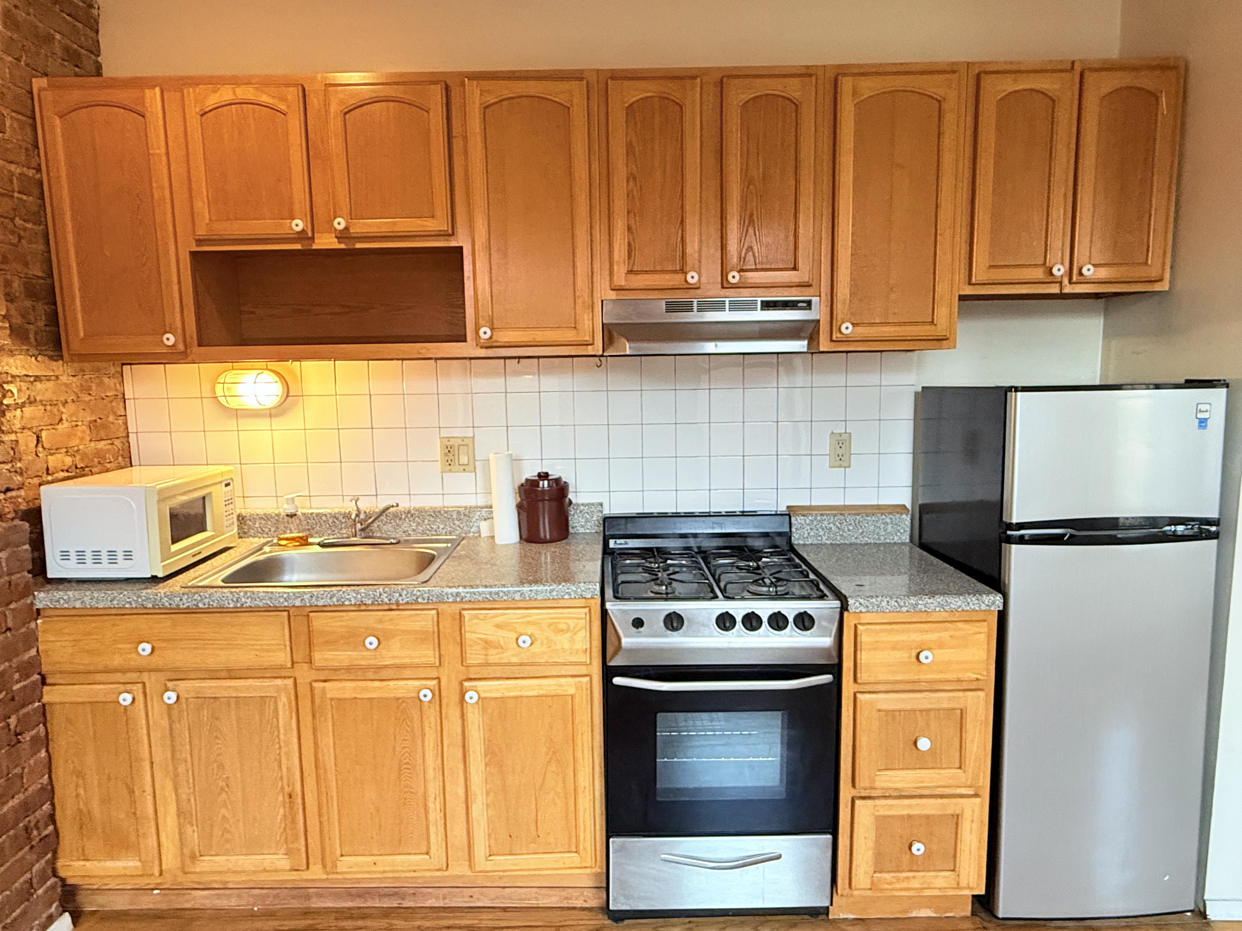 1672 Park Avenue, Unit 4A Manhattan, NY 10035 - Photo 9 of 11 a kitchen with stainless steel appliances granite countertop a stove a sink and a microwave