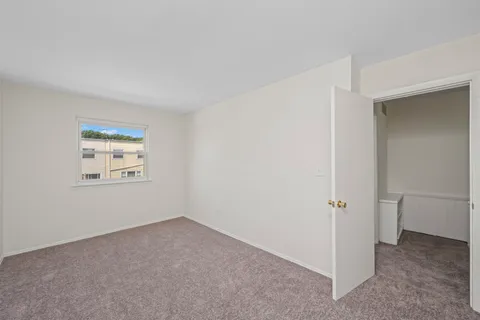 a view of an empty room with closet area