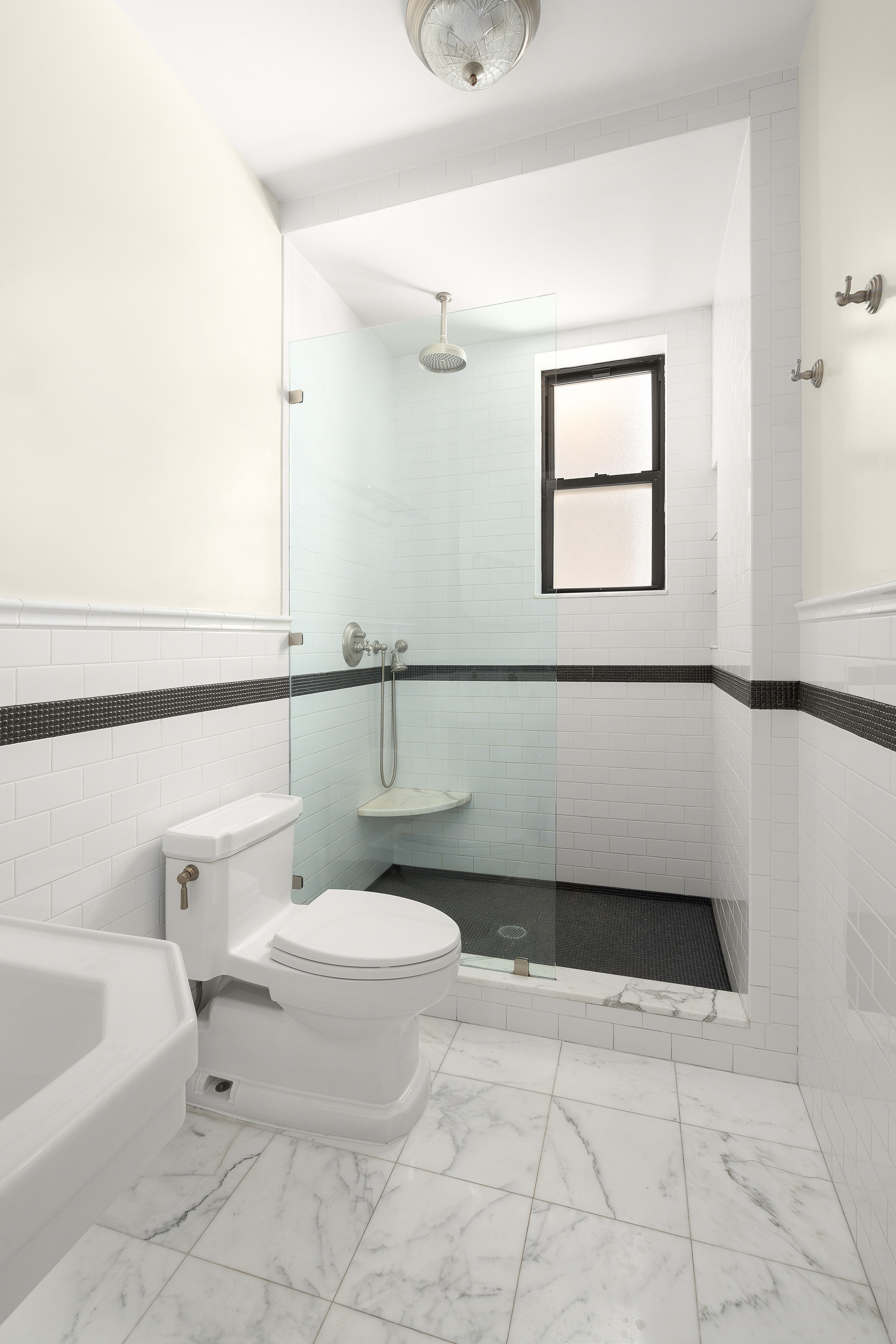 200 West 54th Street, Unit 8G Manhattan, NY 10019 - Photo 7 of 11 a bathroom with a toilet a sink and mirror