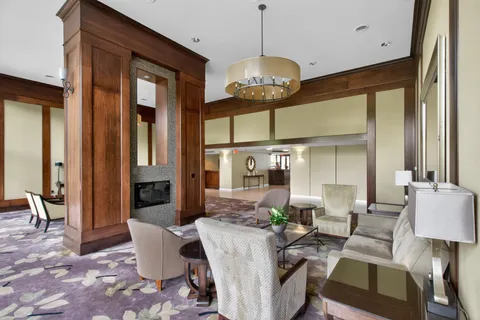 a living room with furniture a dining table and a chandelier