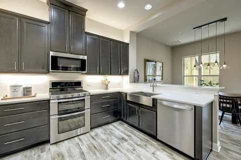a kitchen with granite countertop a sink and steel appliances