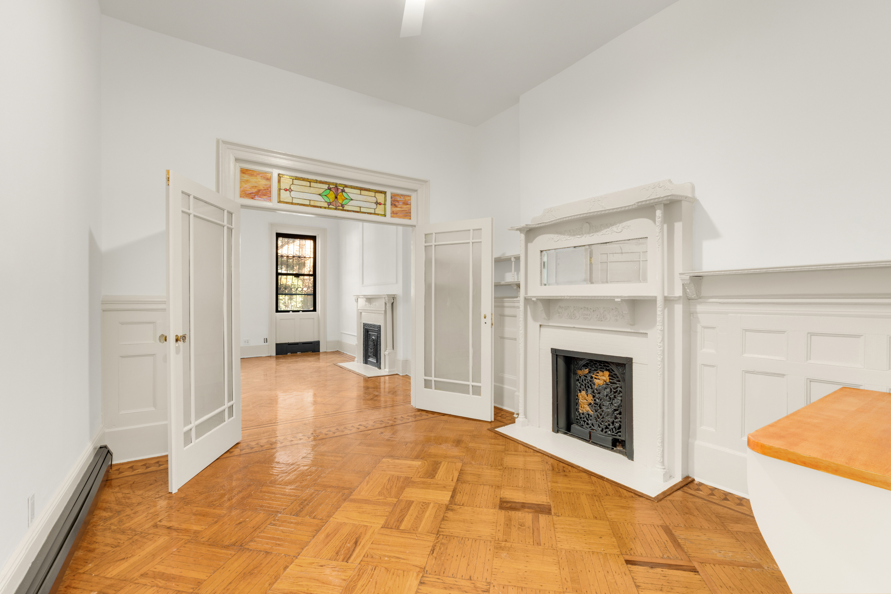 a view of an empty room with fireplace and a window