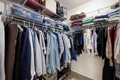 a view of walk in closet with clothes and shoes